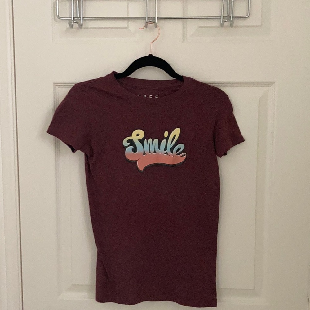 A maroon top with the word smile on the front
